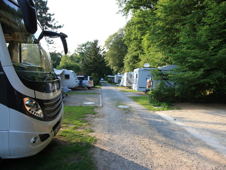 Ein Wohnmobil parkt am Rand eines Feldwegs auf dem Campingplatz.